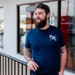 A lifestyle image of someone wearing a Crew T Shirt. The front of the navy blue shirt has a white FDC pike pole logo on the chest.