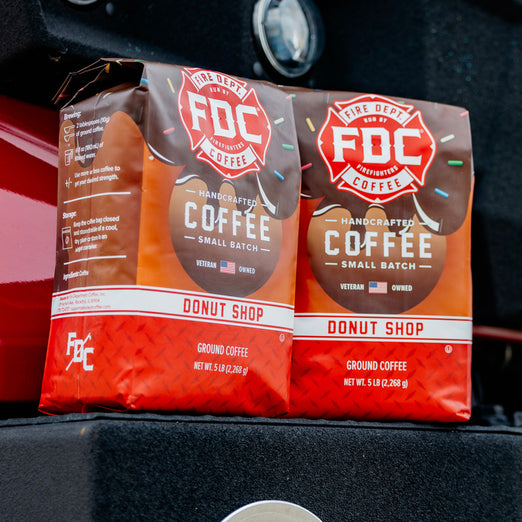 Two 5lb bags of Donut Shop Coffee sitting on a fire truck.