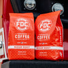 Two 5lb Bags of Original Medium Roast resting on a fire truck.