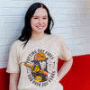 A lifestyle image of someone wearing the Female Firefighter Shirt. The front of the shirt features imagery of a female firefighter with text that reads, "Putting out fires for over 200 years".