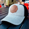 A lifestyle image of a Leather Patch Hat in Gray sitting on a table