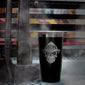 Front view of black tumbler with engraved FDC skull logo. The tumbler is sitting next to a set of firefighter tools.