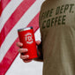 Someone holding a red Maltese Cross 20 ounce tumbler