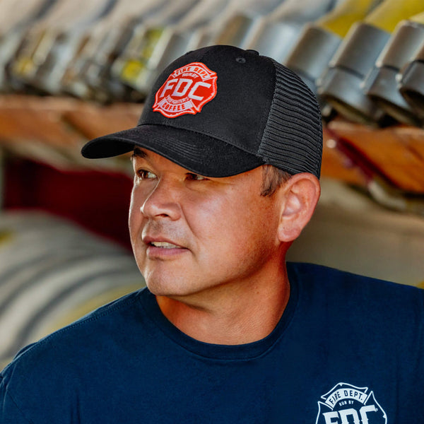 Side view of the front of the FDC black mesh hat with the FDC maltese cross logo on the front