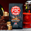 A bag of Fire Department Coffee's 12 oz Marshmallow Brownie Coffee set on a table with a pile of brownies and toasted marshmallows next to it.