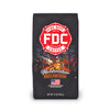 A bag of Fire Department Coffee's 12 oz Marshmallow Brownie Coffee with a red section accross the top that says "Fire Dept. Coffee". The art on the bag features a beaver holding a pike pole with a marshmallow and brownie on it over a campfire. The title reads, "Marshmallow Brownie" and there is a veteran owned badge with an American flag in the bottom right corner.