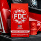 A red 5-lb coffee bag of Fire Department Coffee’s Medium Roast Coffee stands on a black surface with a red fire hydrant-shaped mug beside it, set against a red and black fire truck background.