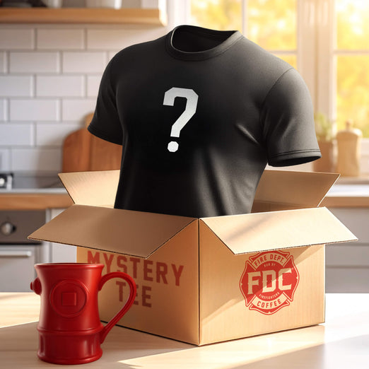 Black mystery t-shirt with a question mark in a cardboard Fire Department Coffee box labeled ’Mystery Tee’. Next to the box with the shirt inside is classic Fire Department Coffee Hydrant Mug.
