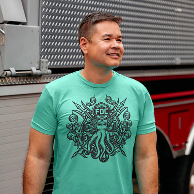 Five Fire Dept. Coffee T-shirts displayed on a white background in vintage white, mint, heather gray, military green, and black color options, each featuring a Shellback-inspired graphic with an FDC logo and octopus design on the front
