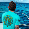 A lifestyle image of someone wearing the Shellback Shirt. The back of the shirt features imagery of King Neptune and says "Ancient Order of the Deep" with the FDC pike pole logo above in yellow.
