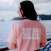 A lifestyle image of someone wearing the Stay Back Shirt in Pink. The back of the shirt reads, "Stay back 500 feet until I've had my coffee" in white lettering.
