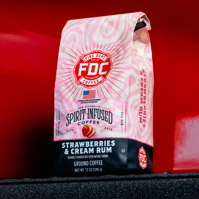 12oz bag of Strawberries and Cream Rum Infused Coffee with pink and black design on a white background.