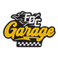 The word ”Garage” in yellow text with ”FDC” in flames above and a checkered flag design below.