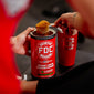 Someone scooping out Fire Department Coffee’s Instant Coffee Protein Powder sitting next to a red maltese cross tumbler