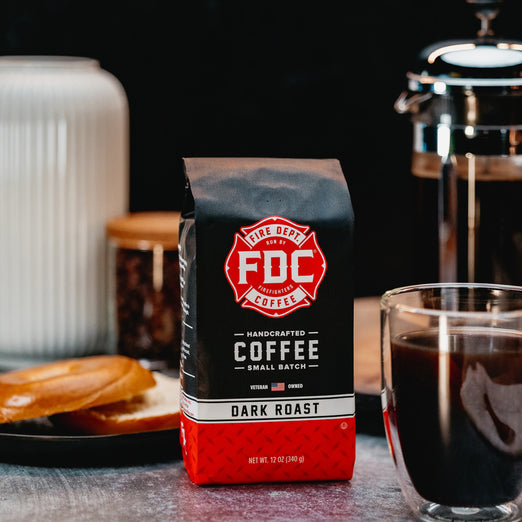 An image of FDC’s Dark Roast on a table surrounded by coffee brewing items.