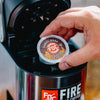 Someone placing a Donut Shop Coffee Pod in a brewing machine