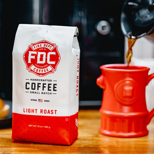 A bag of light roast coffee sitting on a table with a Fire Hydrant Coffee mug sitting next to it