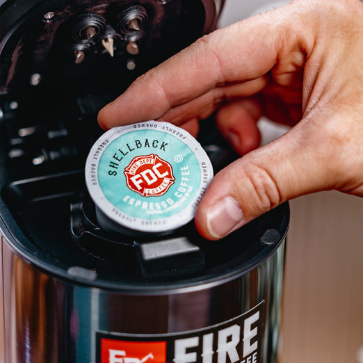 Someone placing a Shellback Espresso Coffee Pods in a brewing machine