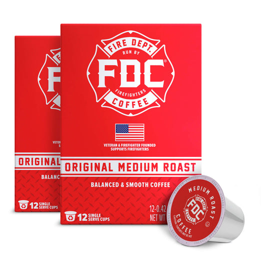 A red box of FDC Fire Department Coffee Original Medium Roast coffee is shown with two single-serve cups in front on a white background.