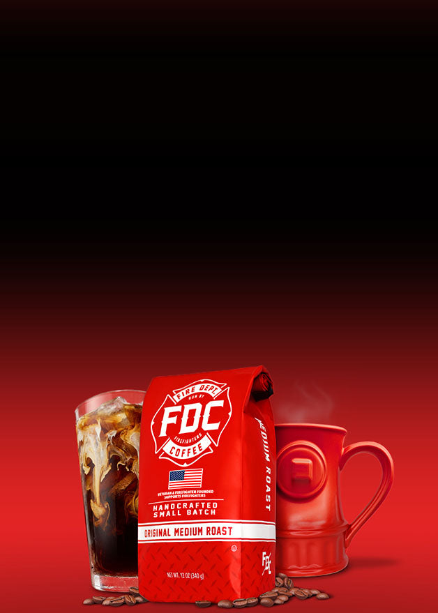 A red bag of FDC Coffee Medium Roast stands on coffee beans beside a glass of iced coffee and a red ceramic mug against a dark red gradient background.