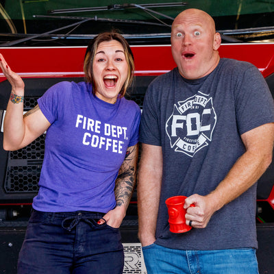 Three Fire Department Coffee Mystery T-Shirts in red, gray, and green with a question mark on each shirt. Underneath the shirts in bold text reads, "Mystery Shirt Selected At Random".