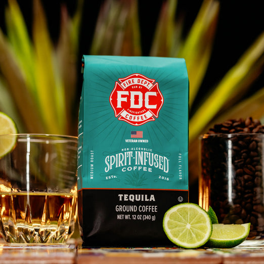 An image of FDC’s Tequila Infused Coffee next to a shot of tequila and a glass of roasted coffee beans. 