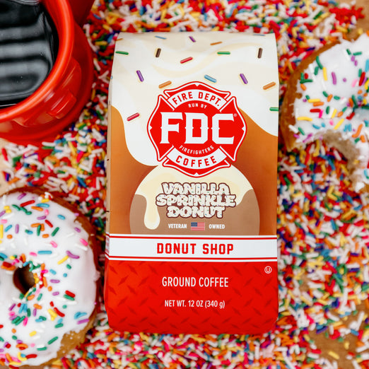 Fire Dept. Coffee’s 12 ounce Vanilla Sprinkle Donut Shop Coffee surrounded by rainbow sprinkles, donuts, and a full hydrant mug.