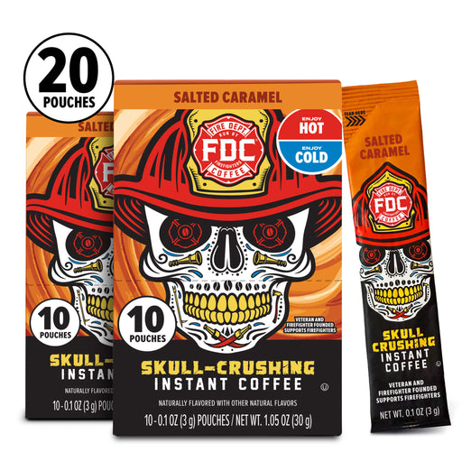 Three boxes of FDC Skully-Crushing Instant Coffee in Salted Caramel flavor, with one box shown open to reveal a single sachet. The packaging features a bold skull graphic wearing a firefighter helmet, with a black, orange, white, and red design.