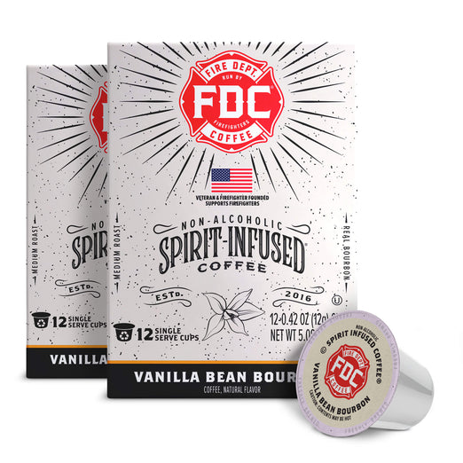 Two boxes of FDC Fire Department Spirit Infused Coffee next to a single vanilla bean coffee capsule on a white background.