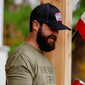 A 3/4 angle image of man wearing the Fire Department Coffee Black Keystone Hat.