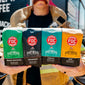 A firefighter holding up the four coffees included in the Spirit Infused Coffee Bundle.