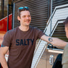 A man wearing the Salty Shirt next to a fire truck.