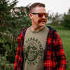 A man in sunglasses wearing the Wildland Skull shirt under a flannel jacket.