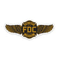 Sticker with FDC’s maltese cross logo in gold and black with golden wings on either side.