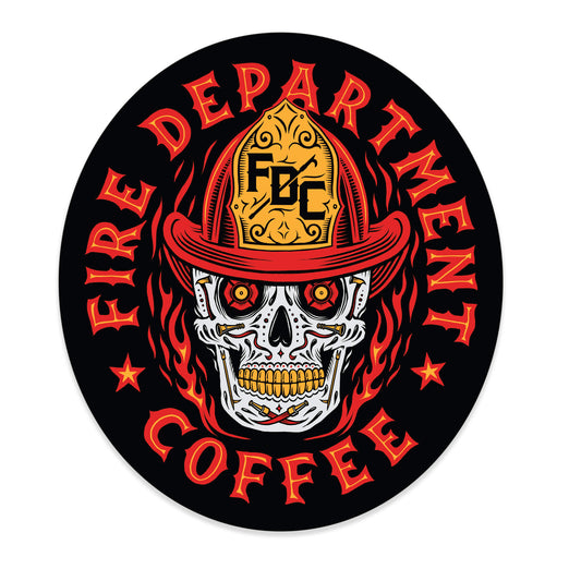 Sticker with a skull wearing an FDC fire helmet surrounded by flames in the center. Around the skull is text that reads ”Fire Department Coffee”.